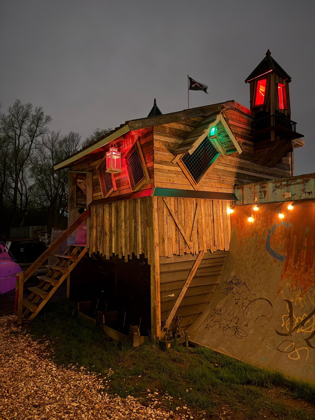 Het verlichte houten fort met rode en groene accenten