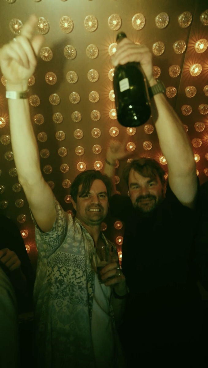 Twee vrienden vieren het feest voor de verlichte DJ-booth