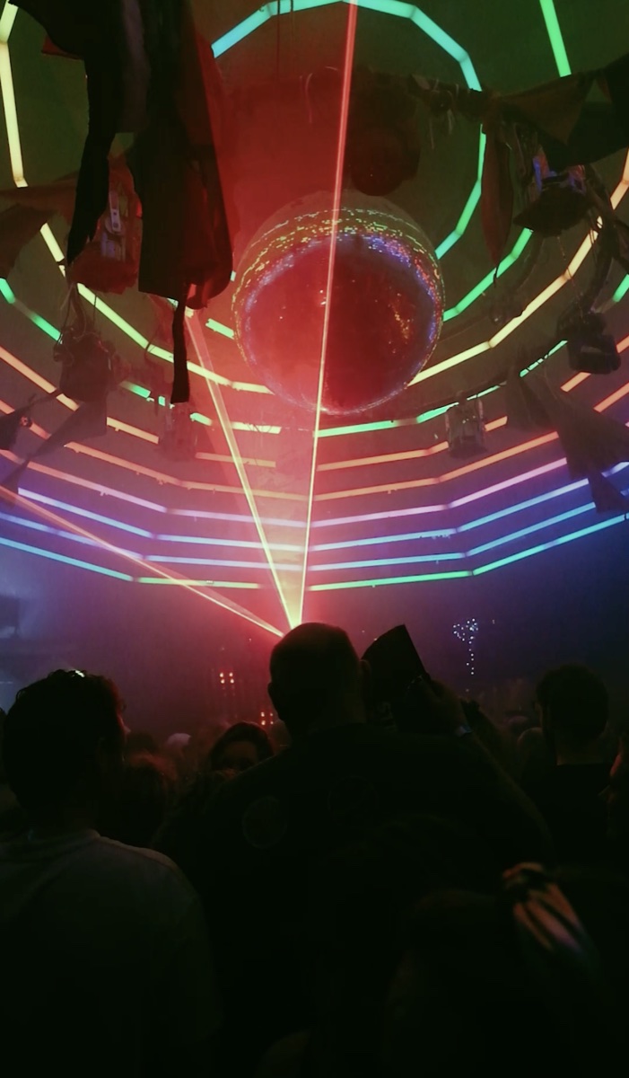 Dansvloer onder lasers en een spiegelbol tijdens INTO THE HILLS